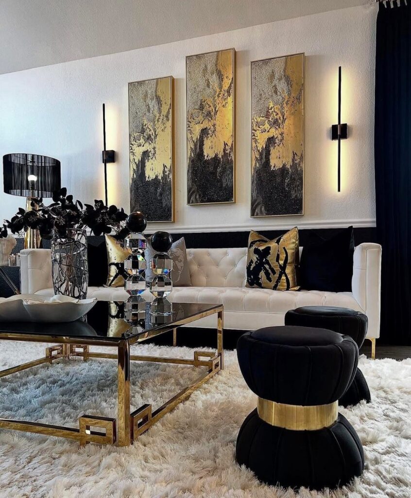 Luxurious living room with black and gold accents, white sofa, and abstract art.