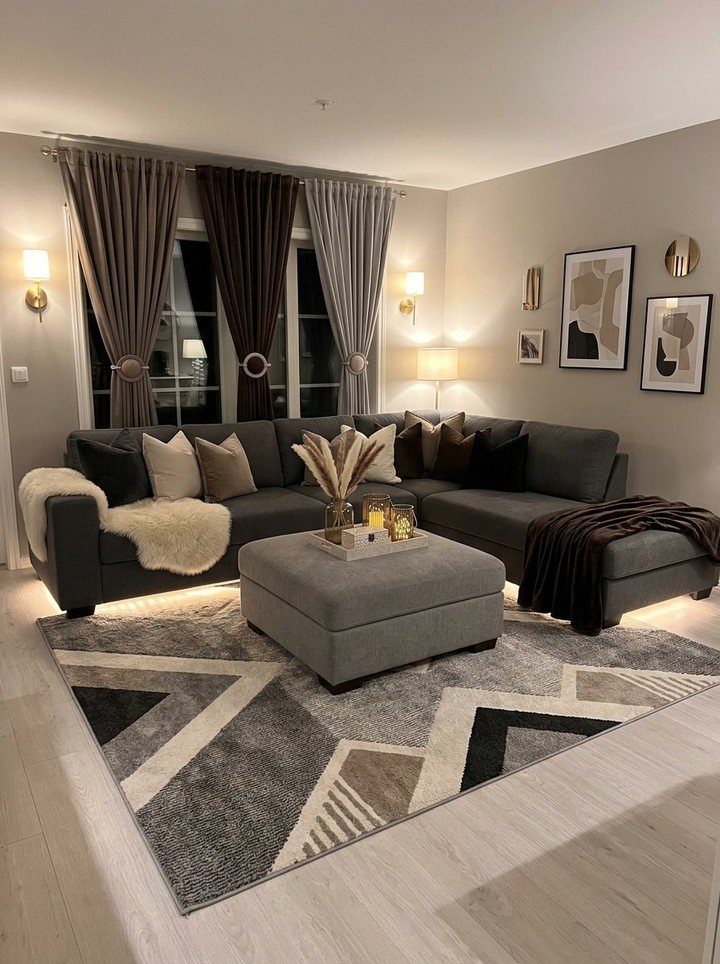 Grey sectional sofa and geometric rug with brown and grey drapery curtains.