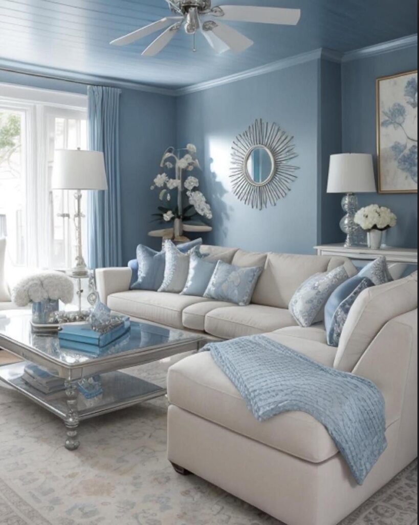 Light blue living room with cream sectional sofa, mirrored coffee table, and sunburst mirror.