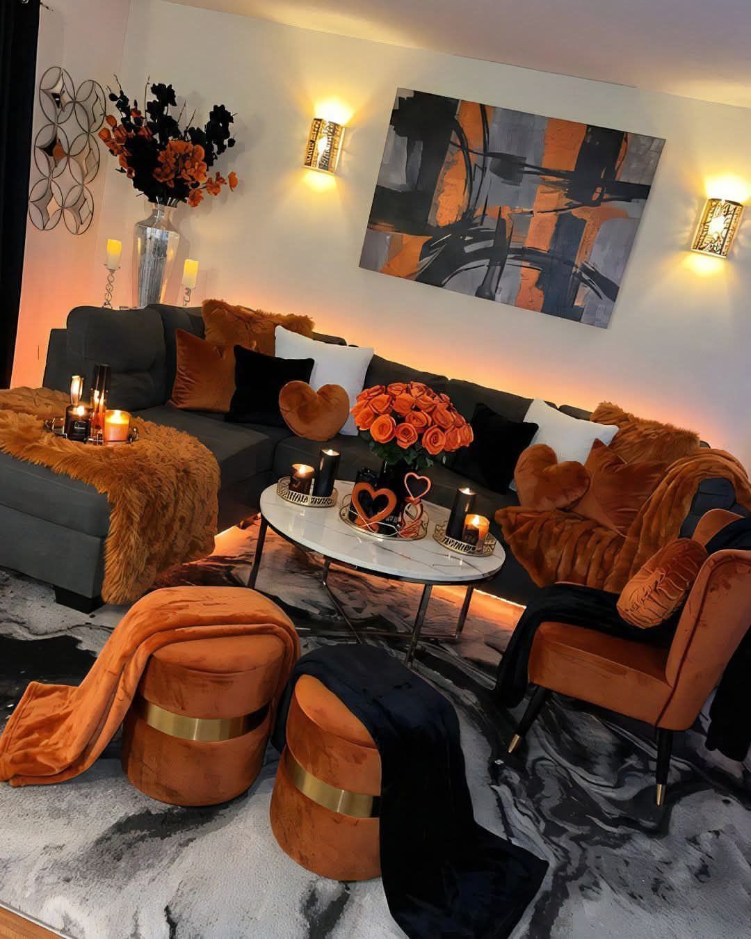 Modern living room with grey sofa, orange velvet accents, and abstract wall art.