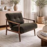 Dark grey mid-century modern accent chair in a bright, minimalist living room setting.